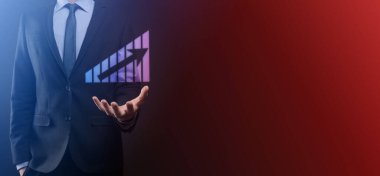 Holografik grafikler ve borsa istatistikleri tutan işadamı kâr elde ediyor. Büyüme planlama ve iş stratejisi kavramı. İyi ekonomi formunun dijital ekran görüntüsü