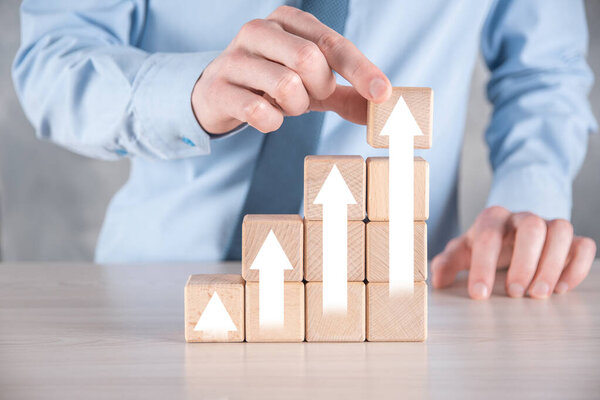 Развитие бизнеса к успеху и растущей концепции роста. Бизнесмен пытается выстроить деревянные блоки в растущие графики