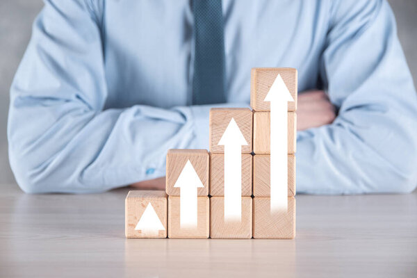 Развитие бизнеса к успеху и растущей концепции роста. Бизнесмен пытается выстроить деревянные блоки в растущие графики