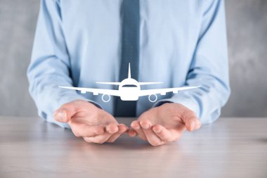 İş adamı elinde bir uçak ikonu tutuyor. Online bilet alımı. Seyahat..
