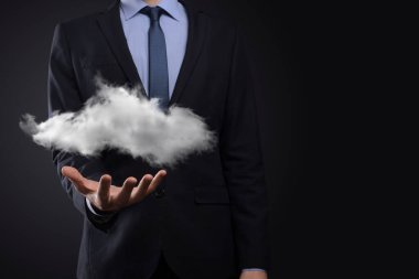 İş adamı el ele tutuşur. Bulut hesaplama konsepti, eli bulutlu genç iş adamına yakınlaşır. Bulut servisi kavramı.