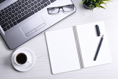 Bilgisayarlı masa masası, akıllı telefon, bir fincan kahve ve malzeme, ahşap arka planda. Kopyalama alanı olan üst görünüm, düz yatay