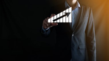 Holografik grafikler ve borsa istatistikleri tutan işadamı kâr elde ediyor. Büyüme planlama ve iş stratejisi kavramı. İyi ekonomi formunun dijital ekran görüntüsü