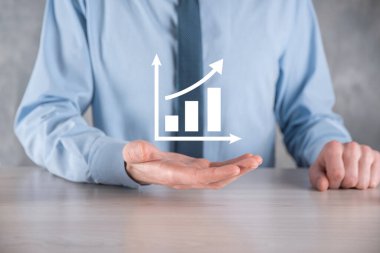 İş adamı artan ekran grafiği, pozitif büyüme ikonu okları üzerinde duruyor. Yaratıcı iş grafiğine yükselen oklarla işaret ediyor. Finansal, ticari büyüme kavramı.