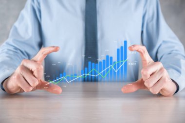İş adamı elinde pozitif kar artışı olan bir grafik tutuyor. Grafik büyümesi ve grafik artışı işlerinde olumlu göstergeler. Daha kârlı ve büyüyen.
