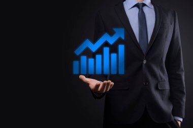 İş adamı artan ekran grafiği, pozitif büyüme ikonu okları üzerinde duruyor. Yaratıcı iş grafiğine yükselen oklarla işaret ediyor. Finansal, ticari büyüme kavramı.