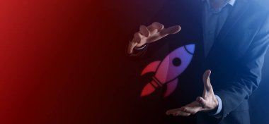 Boş bir iş. Siyah arka planda takım elbiseli bir işadamı ellerini koruyucu bir şekilde tutar. Bakım ve himaye jesti.