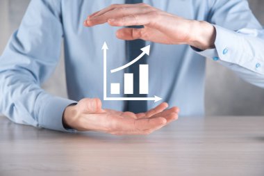 İş adamı artan ekran grafiği, pozitif büyüme ikonu okları üzerinde duruyor. Yaratıcı iş grafiğine yükselen oklarla işaret ediyor. Finansal, ticari büyüme kavramı.