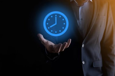 İş adamı, saatin simgesini okla tutar. İşlerin hızlı yürütülmesi. İş zamanı yönetimi ve iş zamanı para kavramlarıdır..