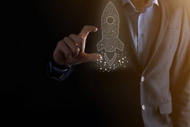 Başlangıç iş konsepti, simge şeffaf roket tutan İşadamı ekrandan koyu arkaplanda ağ bağlantısı ile fırlıyor ve yükseliyor