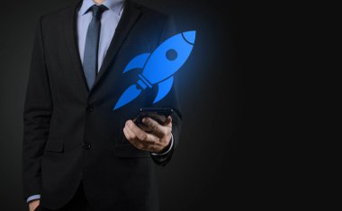 Soyut dijital roket ikonu taşıyan iş adamı konsepti fırlatılıyor ve yükseliyor.