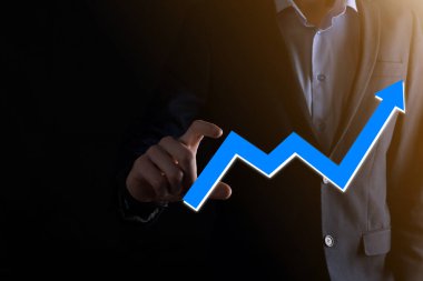İş adamı artan ekran grafiği, pozitif büyüme ikonu okları üzerinde duruyor. Yaratıcı iş grafiğine yükselen oklarla işaret ediyor. Finansal, ticari büyüme kavramı.