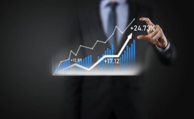 Holografik grafikler ve borsa istatistikleri tutan işadamı kâr elde ediyor. Büyüme planlama ve iş stratejisi kavramı. İyi ekonomi formunun dijital ekran görüntüsü