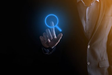 İş adamı ve adam el ele tutuşup cam ikonunu büyütüyorlar. İş dünyası, teknoloji ve internet kavramı