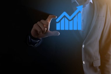 İş adamı elinde pozitif kar artışı olan bir grafik tutuyor. Grafik büyümesi ve grafik artışı işlerinde olumlu göstergeler. Daha kârlı ve büyüyen