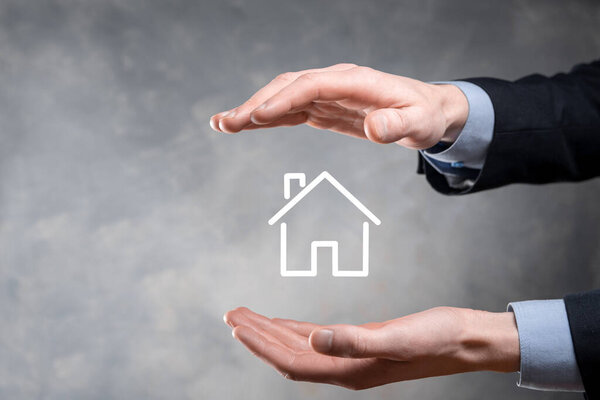 Концепция недвижимости, бизнесмен, владеющий домом на Hand.Property страхование и концепция безопасности. Защитный жест человека и символ дома.