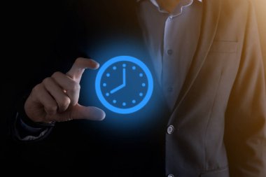 İş adamı, saatin simgesini okla tutar. İşlerin hızlı yürütülmesi. İş zamanı yönetimi ve iş zamanı para kavramlarıdır..