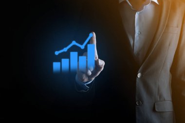 İş adamı elinde pozitif kar artışı olan bir grafik tutuyor. Grafik büyümesi ve grafik artışı işlerinde olumlu göstergeler. Daha kârlı ve büyüyen