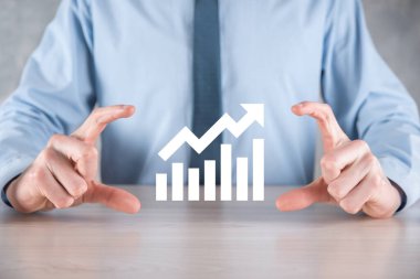 İş adamı elinde pozitif kar artışı olan bir grafik tutuyor. Grafik büyümesi ve grafik artışı işlerinde olumlu göstergeler. Daha kârlı ve büyüyen