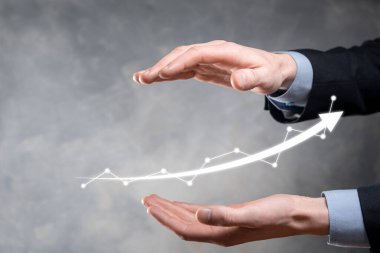 İş adamı artan ekran grafiği, pozitif büyüme ikonu okları üzerinde duruyor. Yaratıcı iş grafiğine yükselen oklarla işaret ediyor. Finansal, ticari büyüme kavramı.