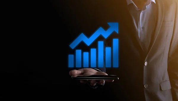 Businessman man holding a graph with positive profits growth. plan graph growth and increase of chart positive indicators in his business.more profitable and growing