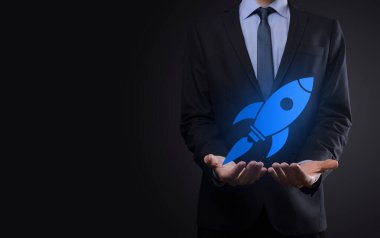 Soyut dijital roket ikonu taşıyan iş adamı konsepti fırlatılıyor ve yükseliyor.