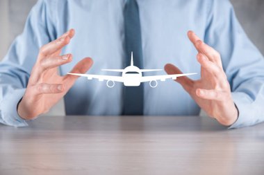 İş adamı elinde bir uçak ikonu tutuyor. Online bilet alımı. Seyahat..