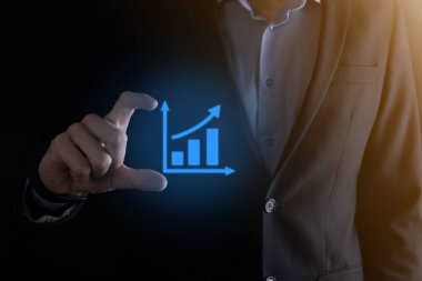 İş adamı elinde pozitif kar artışı olan bir grafik tutuyor. Grafik büyümesi ve grafik artışı işlerinde olumlu göstergeler. Daha kârlı ve büyüyen