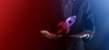 Boş bir iş. Siyah arka planda takım elbiseli bir işadamı ellerini koruyucu bir şekilde tutar. Bakım ve himaye jesti.