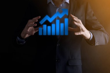 İş adamı elinde pozitif kar artışı olan bir grafik tutuyor. Grafik büyümesi ve grafik artışı işlerinde olumlu göstergeler. Daha kârlı ve büyüyen