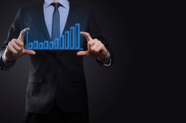 Holografik grafikler ve borsa istatistikleri tutan işadamı kâr elde ediyor. Büyüme planlama ve iş stratejisi kavramı. İyi ekonomi formunun dijital ekran görüntüsü