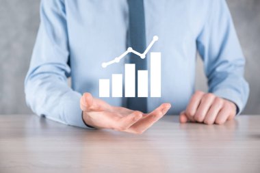 İş adamı artan ekran grafiği, pozitif büyüme ikonu okları üzerinde duruyor. Yaratıcı iş grafiğine yükselen oklarla işaret ediyor. Finansal, ticari büyüme kavramı.
