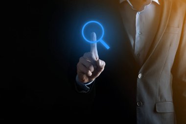 İş adamı ve adam el ele tutuşup cam ikonunu büyütüyorlar. İş dünyası, teknoloji ve internet kavramı