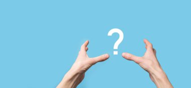 Mavi arkaplanda soru işareti simgesi tutan bir erkek. Kopya alanı olan bir pankart. Metin için yer