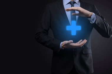 İş adamı, elinde tuttuğu kişi kar, çıkar, gelişme, artı işareti ile temsil edilen CSR gibi olumlu şeyler sunar..