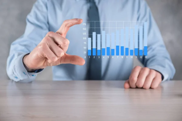 Businessman man holding a graph with positive profits growth. plan graph growth and increase of chart positive indicators in his business.more profitable and growing.