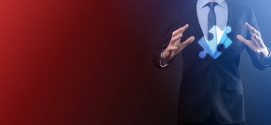 İki şirketin birleşmesini veya ortak girişim, ortaklık, birleşme ve satın alma kavramını temsil eden bulmaca parçalarını birleştiren işadamı elleri.