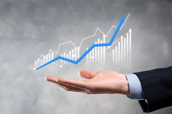 Businessman holding graph growth and increase of chart positive indicators in his business.Investment up concept.analyzing sales data and economic,strategy and planning, Digital marketing and stock market.