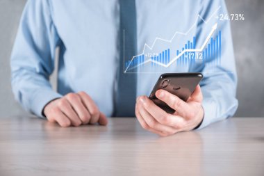 İş adamı elinde pozitif kar artışı olan bir grafik tutuyor. Grafik büyümesi ve grafik artışı işlerinde olumlu göstergeler. Daha kârlı ve büyüyen.