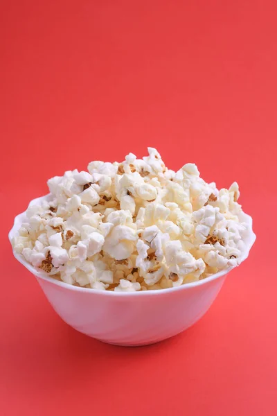 Popcorn in bowl on a red background. Close up. Top view.