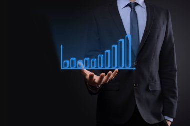 Holografik grafikler ve borsa istatistikleri tutan işadamı kâr elde ediyor. Büyüme planlama ve iş stratejisi kavramı. İyi ekonomi formunun dijital ekran görüntüsü