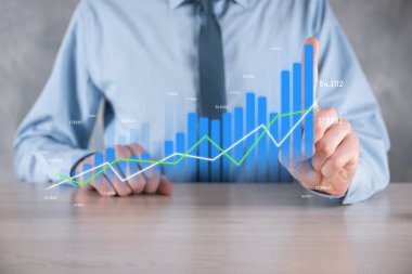 İş adamı elinde pozitif kar artışı olan bir grafik tutuyor. Grafik büyümesi ve grafik artışı işlerinde olumlu göstergeler. Daha kârlı ve büyüyen.