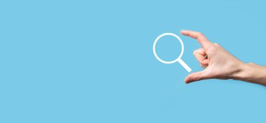 Erkek el büyüteç tutuyor, mavi arkaplanda arama simgesi var. Konsept arama motoru optimizasyonu, müşteri desteği. İnternet Veri Bilgilerine göz atılıyor. Ağ Konsepti