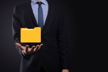 İş adamı dizin simgesini tutuyor. Belge Yönetim Sistemi veya modern bilgisayar bilişim danışmanı tarafından kurulmuş DMS yönetici dosyaları ve kurumsal dosyaları arıyor. İş işleme