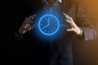 İş adamı, saatin simgesini okla tutar. İşlerin hızlı yürütülmesi. İş zamanı yönetimi ve iş zamanı para kavramlarıdır..
