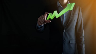 İş adamı artan ekran grafiği, pozitif büyüme ikonu okları üzerinde duruyor. Yaratıcı iş grafiğine yükselen oklarla işaret ediyor. Finansal, ticari büyüme kavramı.
