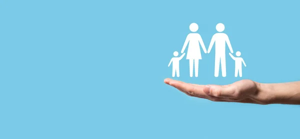 Hand hold young family icon. Family life insurance,supporting and services,family policy and supporting families concepts.Happy family concept.Copy space.mancupped hands showing paper man family.