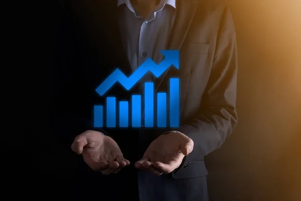 Businessman man holding a graph with positive profits growth. plan graph growth and increase of chart positive indicators in his business.more profitable and growing