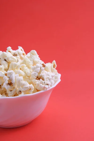 Popcorn in bowl on a red background. Close up. Top view.