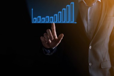 Holografik grafikler ve borsa istatistikleri tutan işadamı kâr elde ediyor. Büyüme planlama ve iş stratejisi kavramı. İyi ekonomi formunun dijital ekran görüntüsü